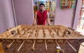 Artesano mexicano está tallando una mesa de futbolito de madera que representa a dioses mayas y aztecas