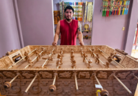Artesano mexicano está tallando una mesa de futbolito de madera que representa a dioses mayas y aztecas