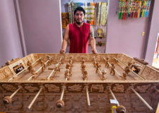 Artesano mexicano está tallando una mesa de futbolito de madera que representa a dioses mayas y aztecas