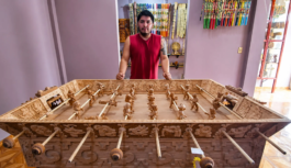 Artesano mexicano está tallando una mesa de futbolito de madera que representa a dioses mayas y aztecas